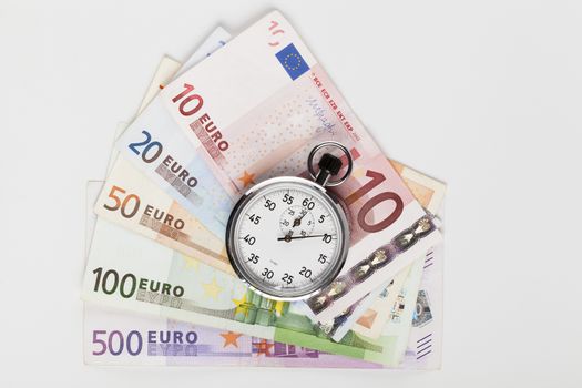 Different euro banknotes with silver analog stopwatch