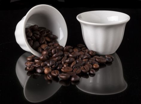 Pair Of White traditional arabic small coffee cup on black background with reflection and coffee Beans