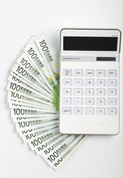One hundred Euro banknotes with white calculator isolated on white