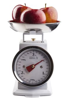 Red apples on white analog scale isolated on white background