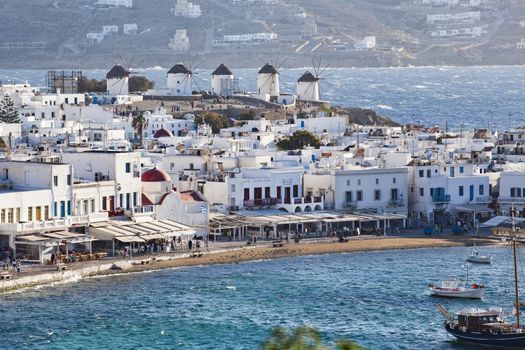 panoramic view of the Mykonos town harbor with famous windmills from the above hills on a sunny summer day, Mykonos, Cyclades, Greece