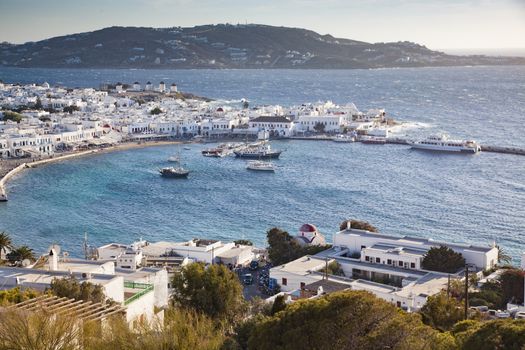 panoramic view of the Mykonos town harbor with famous windmills from the above hills on a sunny summer day, Mykonos, Cyclades, Greece