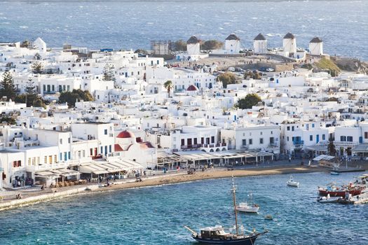 panoramic view of the Mykonos town harbor with famous windmills from the above hills on a sunny summer day, Mykonos, Cyclades, Greece