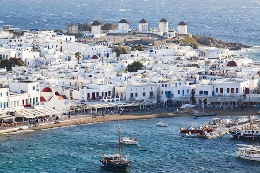 panoramic view of the Mykonos town harbor with famous windmills from the above hills on a sunny summer day, Mykonos, Cyclades, Greece