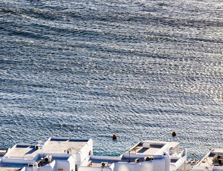 panoramic view of the Mykonos town harbor with famous windmills from the above hills on a sunny summer day, Mykonos, Cyclades, Greece