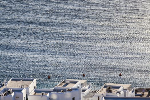 panoramic view of the Mykonos town harbor with famous windmills from the above hills on a sunny summer day, Mykonos, Cyclades, Greece