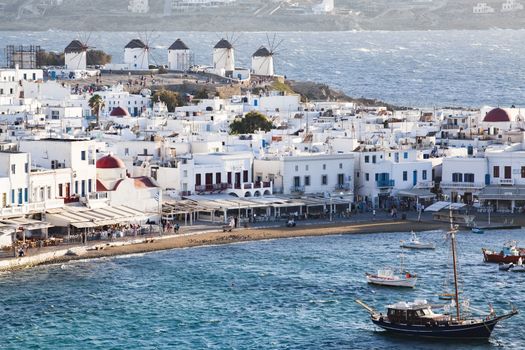 panoramic view of the Mykonos town harbor with famous windmills from the above hills on a sunny summer day, Mykonos, Cyclades, Greece