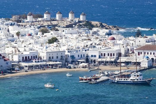 panoramic view of the Mykonos town harbor with famous windmills from the above hills on a sunny summer day, Mykonos, Cyclades, Greece