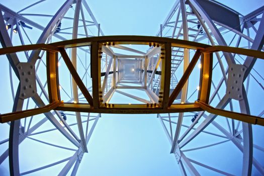 Bottom view of the symmetrical metal supports of the carousel in an amusement park that is lost in the fog.