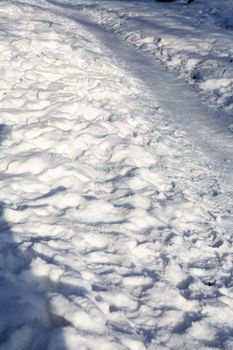 Winter background with footpath across snow