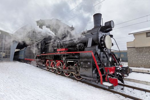 Retro steam train at the station making clouds of steam