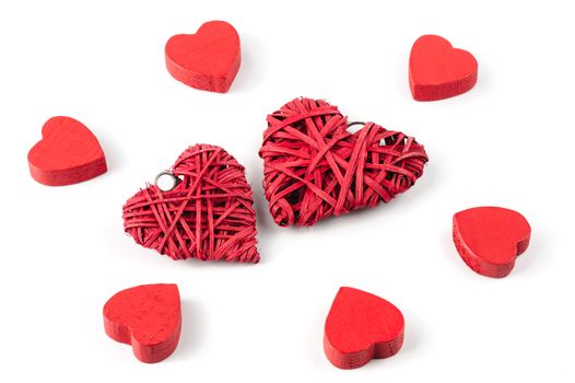 Group or red hearts isolated on white, six roughly carved wooden and two strawy