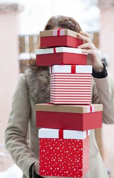 woman returning home from shopping holding pile of christmas present boxes 