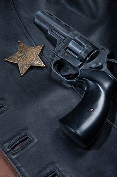 Star badge and revolver on a studio background