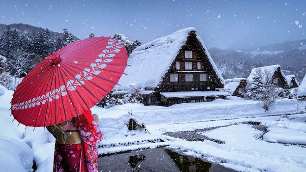 Asian woman wearing japanese traditional kimono at Shirakawa-go village in winter, UNESCO world heritage sites, Japan.