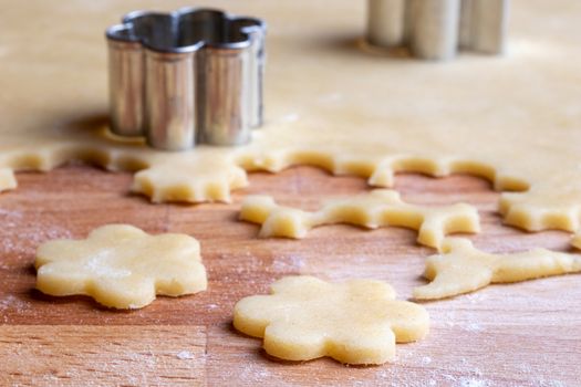 Cutting out shapes from rolled out dough to prepare traditional Linzer Christmas cookies