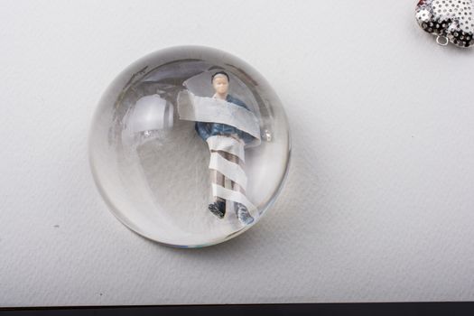 Tiny man in bandage under magnifying glass