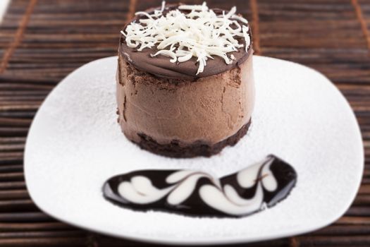 Brown Chocolate mousse cake with whie chocolate on top and heart chocolate shape on suggar powder