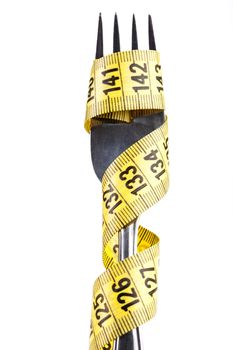 Yellow measuring tape on a fork isolated on white background