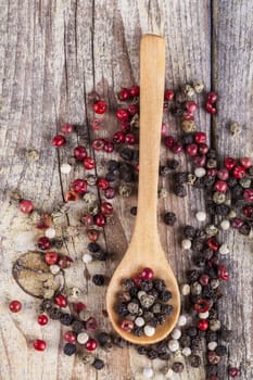 Various type of peppers on wood spoon and old wood table