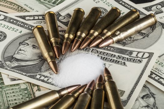 bullets on dollar banknotes with white drug powder