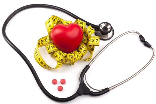 Red heart with stethoscope yellow measuring and red pills isolated on white background