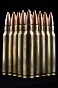 Shiny rifle bullets close-up on black background