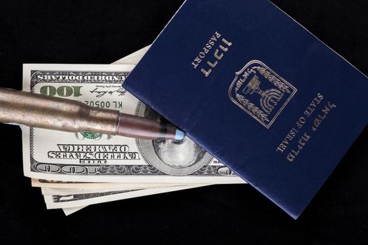 Israelian passport with dollar banknotes and a rifle bullet isolated on black background