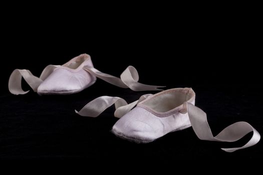Pink small baby balerina shoes on black background