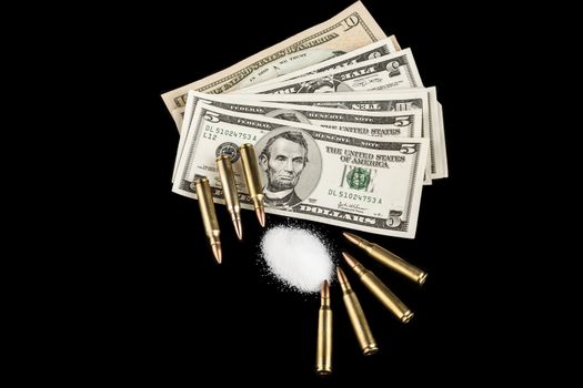 bullets on dollar banknotes with white drug powder on black background