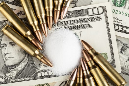 bullets on dollar banknotes with white drug powder 