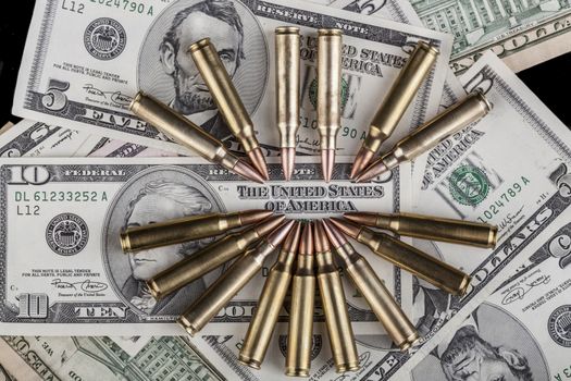 Rifle Bullets pointing at the United States text on a dollar banknote