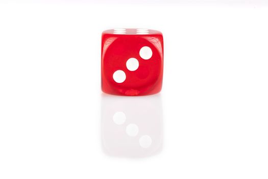 One red dice isolated on white background with reflection