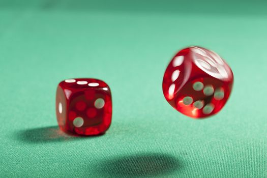 Pair of bouncing red dice blured on green  background