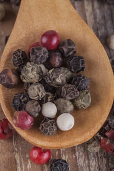 Various type of peppers on wood spoon and old wood table macro close-up