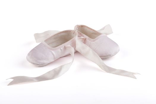 Pair of pink baby ballerina shoes isolated on white background