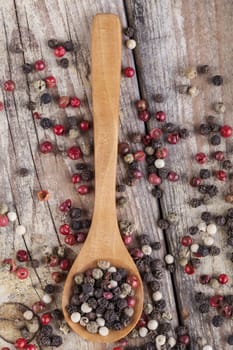 Various type of peppers on wood spoon and old wood table top view