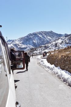 Traffic jam and Highway blockage due to snowfall at Tsomgo Lake. Tourist vehicles lined up to climb in step hill region of himalayan mountain valley.