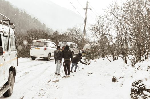 Yumthang Valley, Sikkim, India 1st January 2019: Group of Tourist in winter clothes enjoying snow at snowfall on a day with heavy snow hill slope near Yumthang valley, most picturesque place of Sikkim