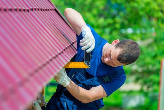 Handyman with the tool during the repair of the roof of the house