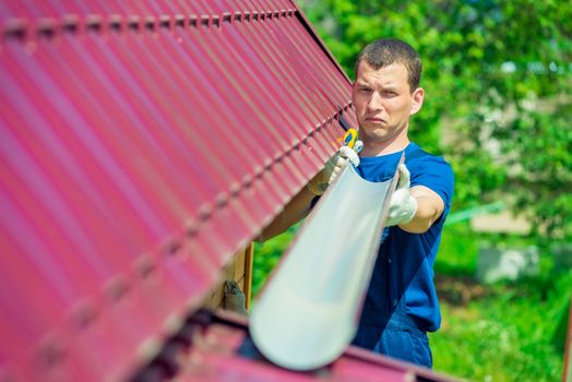 Repairman with a pipe to drain water from the roof, home repair