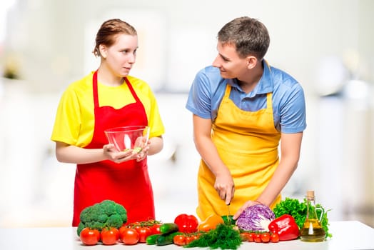 young couple preparing healthy vegetable salad in the kitchen