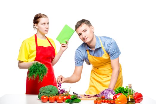 young woman and man cook together diet salad, studio shot isolated