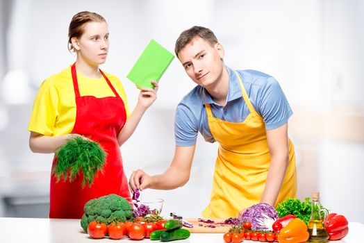 young woman and man cook together diet salad, shooting in the kitchen