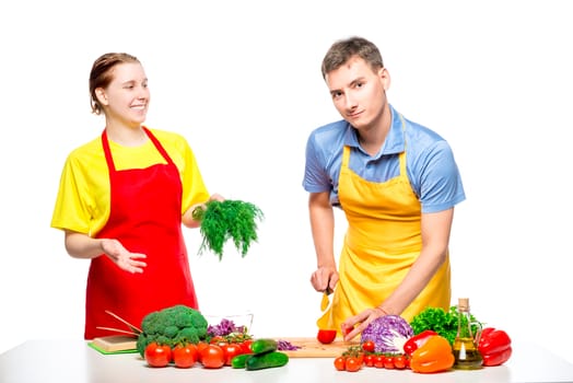 happy couple while cooking salad on white background