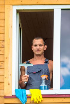 portrait of a man with tools for washing windows in the house