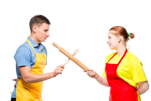 man and woman in an apron with kitchen utensils fighting on a white background