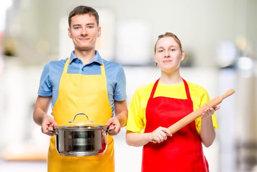 a man with a pan and a woman with a rolling pin portrait in the kitchen