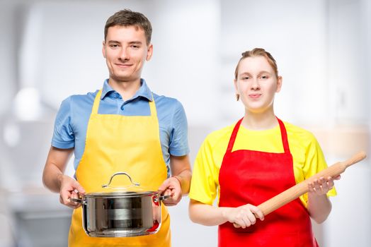 young man with a pan and a woman with a rolling pin in the kitchen