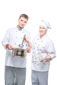 successful professional chefs with pan and a ladle on a white background posing